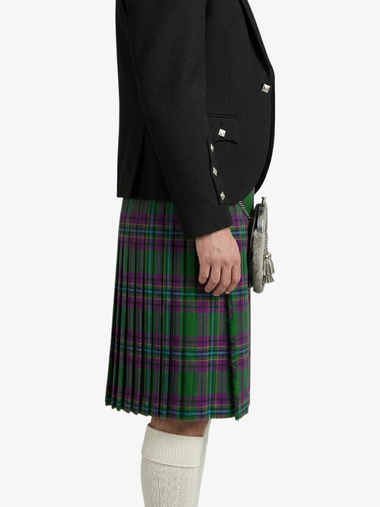 Person wearing a black jacket and green plaid kilt on a white background
