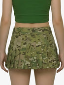 Person wearing a green camouflage skirt and green top on a white background
